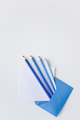 selective focus, blue pencils and white paper sheet out of the blue envelope