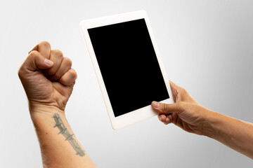 Angry, emotional. Close up male hands holding tablet with blank screen during online watching of popular sport matches, championships. Copyspace for ad. Devices, gadgets, technologies concept.