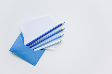 selective focus, blue pencils and white papers out of the blue envelope with copy space on top
