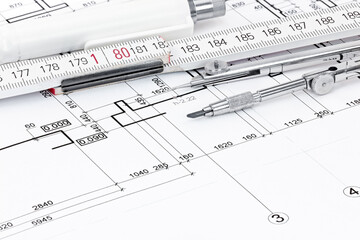 drawing compass, folding rule, pen on architectural drawing background