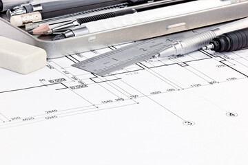 ruler, eraser and pens on graphical blueprints of house interior macro view