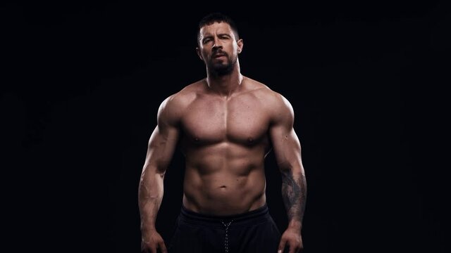 Fit and sporty bodybuilder over black background. Bodybuilder in studio. Sport and fitness.