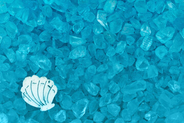 Blue textured beach glass with seashell closeup background
