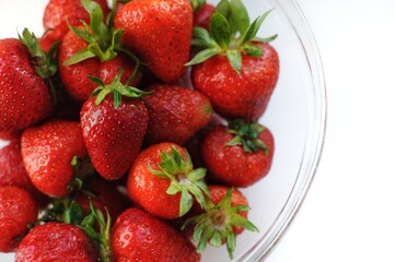Fototapeta na wymiar Summer vitamin fruits in a bowl. Home strawberry close up background. 