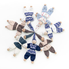 7 gen&auml;hte P&uuml;ppchen, Lumpenkasperle, aus Stoffresten mit Zipfelm&uuml;tzen im Kreis auf wei&szlig;em Untergrund