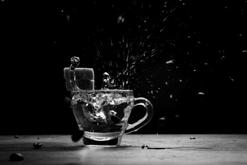 Beans and sugar are splashing in a cup of coffee