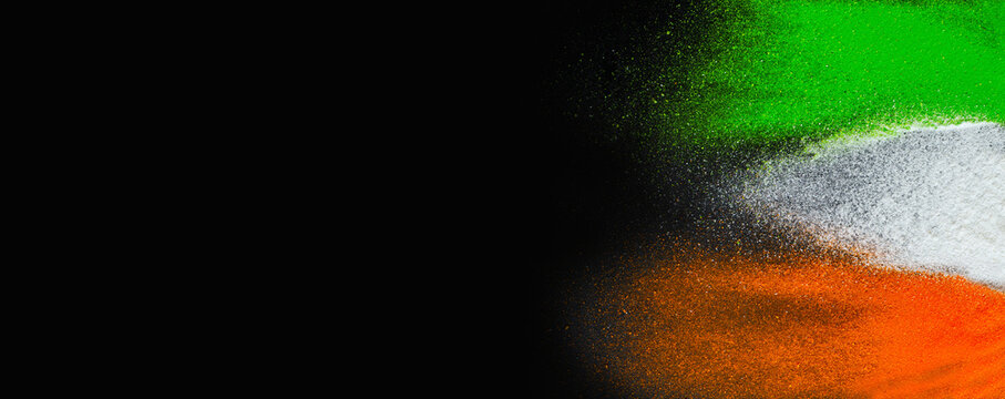 Indian Republic Day celebration background banner. Red, green and saffron color powders splashed over dark background.