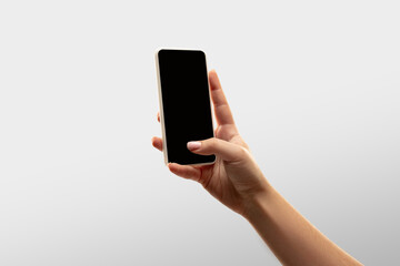 Fototapeta na wymiar Scrolling. Close up female hands holding smartphone with blank screen during online watching of popular sport matches, championships. Copyspace for ad. Devices, gadgets, technologies concept.
