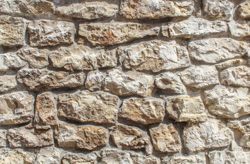 Aged wall made of stones and concrete. Full frame texture backdrop. 