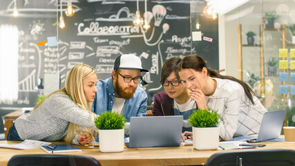 Diverse Team of Young Developers Have Team Meeting Using Laptop. Beautiful Young People in Bright...