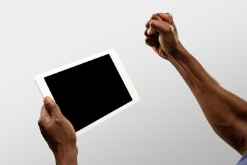 Motivation, fist. Close up male hands holding tablet with blank screen during online watching of popular sport matches, championships. Copyspace for ad. Devices, gadgets, technologies concept.