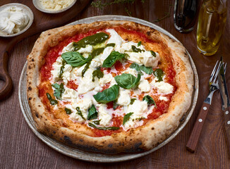High Angle View of Pizza with tomatoes, basil and stracciatella. rome pizza on dark a wooden table. Healthy food