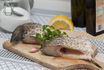 
Fish on the table, and next to it is parsley and a lemon