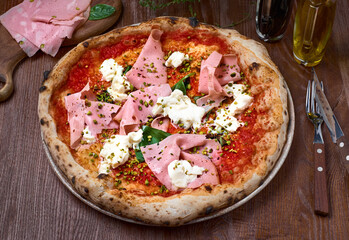 Italian pizza with mortadella and cheese on dark a wooden table. Healthy food
