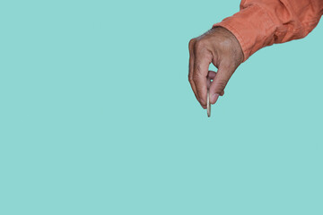 Fototapeta premium Hand picking coin-operated isolated on blue background minimal or copy space.