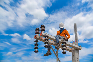 Working on a high ground Electricians are climbing on electric poles to install power lines.