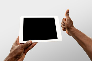 Thumb up, like. Close up male hands holding tablet with blank screen during online watching of popular sport matches, championships. Copyspace for ad. Devices, gadgets, technologies concept.