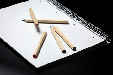 Flat lay view of white notebook , color pencils  on a table. Preparing for a school. Back to school. Remote learning. Learning online.