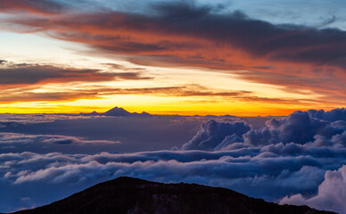 Fototapeta na wymiar Pinkish cloudscape with mt. Rinjani at horizon. View from mt. Agung at sunrise. Bali, Indonesia.