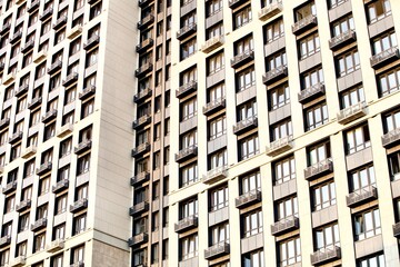 Modern residential skyscrapers facade close-up. Commercial real estate. Modern apartment buildings design. Many windows in the wall of a modern house. Residential city tower.