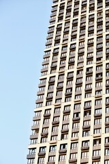 Fototapeta premium Modern residential skyscrapers facade close-up. Commercial real estate. Modern apartment buildings design. Many windows in the wall of a modern house. Residential city tower.