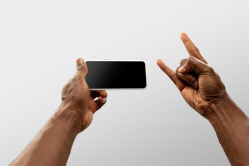 Cool, drive, rock horn. Close up male hands holding smartphone with blank screen during online watching of popular sport matches, championships. Copyspace for ad. Devices, gadgets, technologies