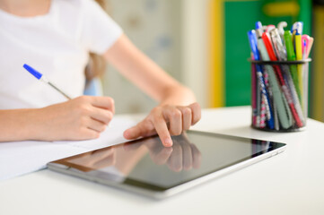 The student’s hand controls the tablet. Online home training. 