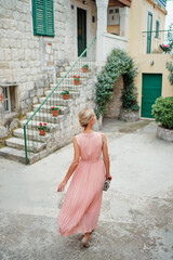 Traveling by Europe. Happy young woman in elegant dress walking by streets in Split, Croatia.