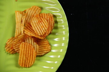 savory snacks with a spicy, salty and sweet orange color on a leaf-shaped green plate