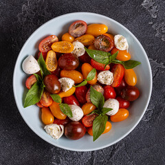Italian caprese salad with tomatoes, mozzarella cheese, basil, olive oil.