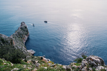 Beautiful landscape with rock cape and ship sailing sea. Alanya, Turkey.