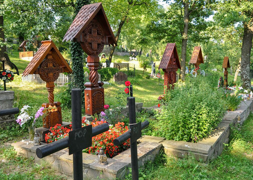 DESESTI, MARAMURES, ROMANIA, SUMMER 2018..Graves of the cemetery of the beautiful wooden orthodox church of San Parascheva or Desesti, Unesco World Heritage.