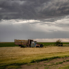 Fototapeta premium Old, abandoned vehicles on the Great Plains as Severe Weather Approaches
