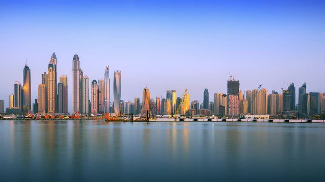Dubai Marina skyline at dusk, time lapse footage with the sea in the foreground and beautiful, changing colors of the sky and the buildings
