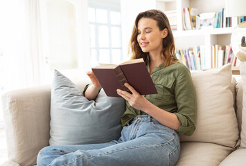 Woman reading book while sitting on the couch