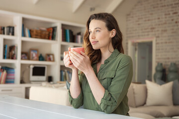 Woman holding coffee cup at home