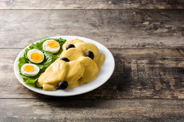 Traditional Peruvian papa a la huancaina on wooden table. Copy space	