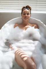 Woman relaxing in a bathtub
