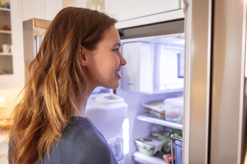 Woman opening the fridge at home