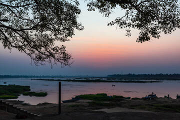 Fototapeta na wymiar A colorful dawn over the river Narmada with sunrise at Cheepaner Ghat, Madhya Pradesh, India.