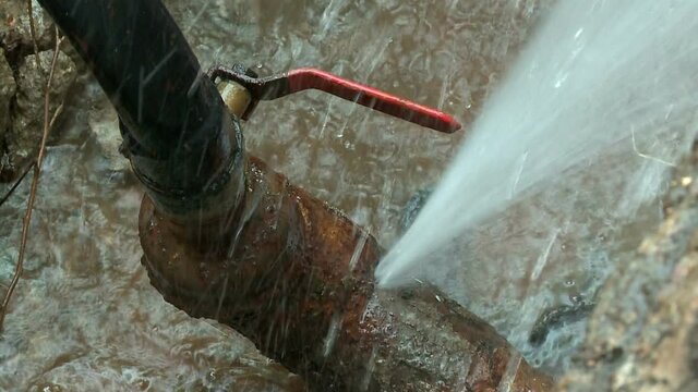Water flows from a rusty water pipe. Water accident