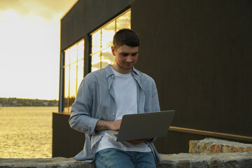 Young man working in a laptop outdoor. Freelancer