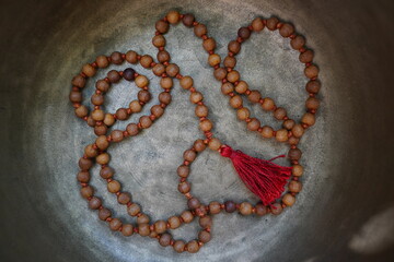 Bronze Tibetan singing bowl with wooden Mala in the bowl.