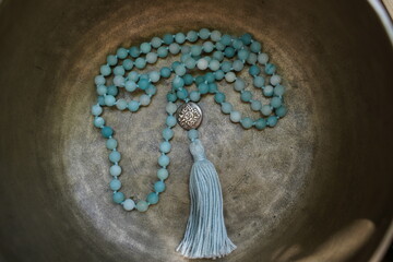 Bronze Tibetan singing bowl with torquise Mala in the bowl.