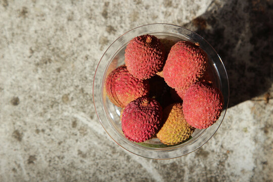 A plastic cup filled with litchis. Organic farming concept image. 