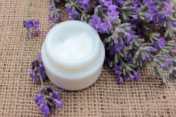 Obraz na płótnie Canvas DIY face or eye cream with fresh lavender flowers on burlap fabric texture. Organic herbal cosmetic concept. Selective focus 
