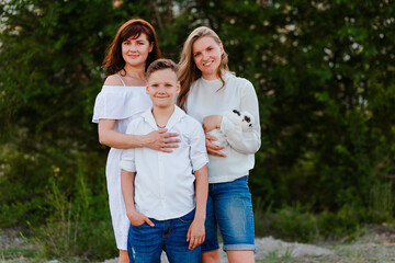 Obraz premium A mother and two teenage children summer against a natural backdrop. children and pets.