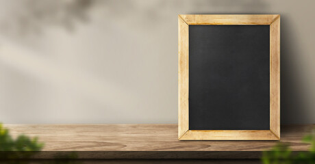blackboard on wood table background with sunlight window and leaf shadow on wall with blur indoor green plant.panoramic banner mockup for display of product,3d rendering