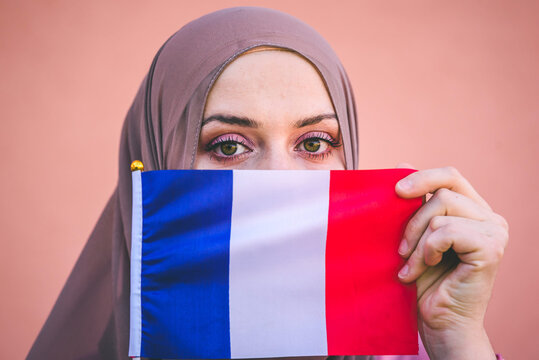 Muslim woman in hijab holds flag of France