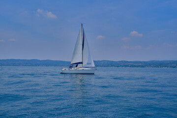 White yacht with a sail in motion